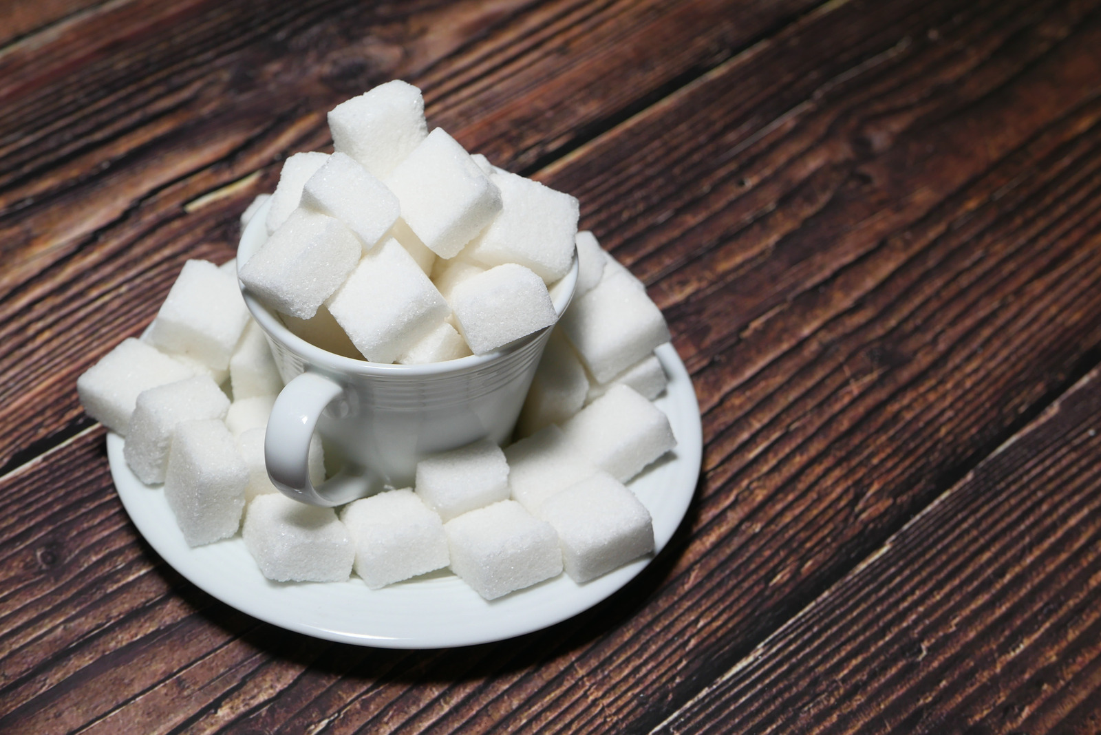 Sugar Cubes In A Tea Cup On Wooden Table